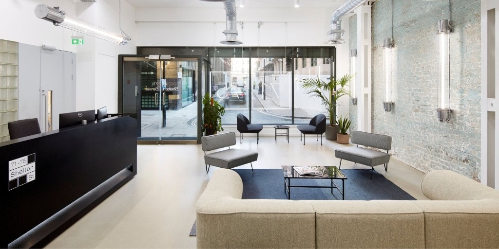 Reception and lounge at 71–75 Shelton Street, Covent Garden: glass frontage, black reception unit, and seating area. By appointment for client working sessions in London with Northbrik.